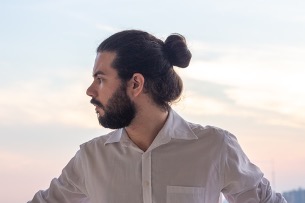 man with tied dark long hair and beard